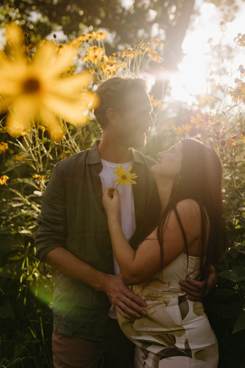 expectant couple holiding flowers during a maternity photoshoot