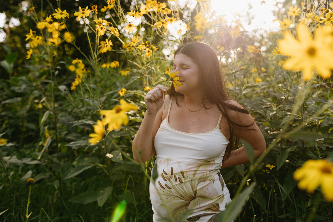 pregnant mom-to-be surrounded by yellow wildflowers in delta park, johannesburg, during a maternity photoshoot