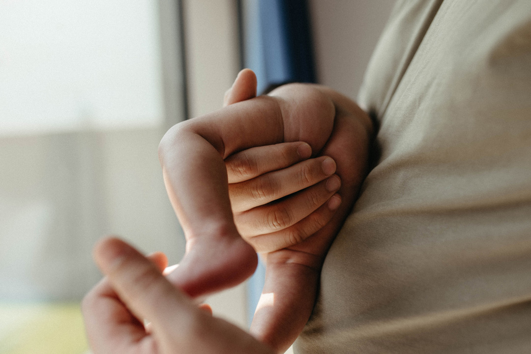 newborn baby in dad's arms
