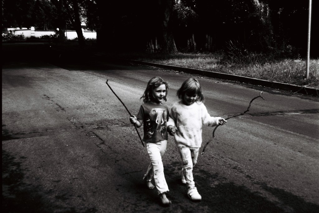 twins walking together in black and white film 35mm
