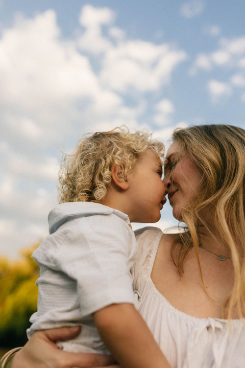 Mother playing with two toddlers in natural light during storytelling family session Gauteng photographer