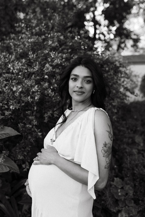 Artistic maternity photograph with jacaranda petals during emotive outdoor session Pretoria