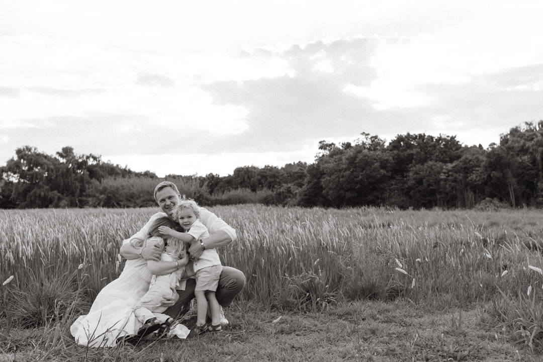 Family of four laughing together during golden hour photoshoot in Johannesburg park