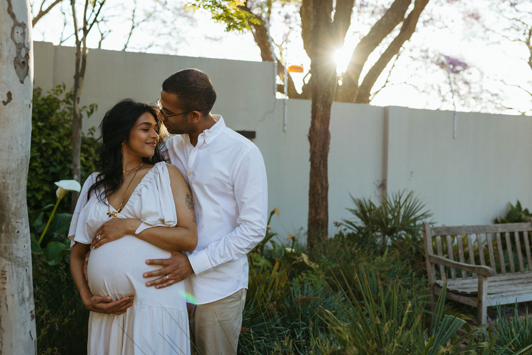 Expectant couple embracing under jacaranda trees during maternity photoshoot Johannesburg spring