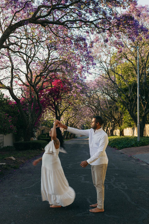 Pregnant woman in flowing dress under jacaranda trees golden hour maternity shoot Johannesburg