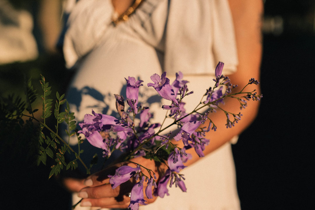 Artistic maternity photograph with jacaranda blooms during storytelling pregnancy session Johannesburg photographer